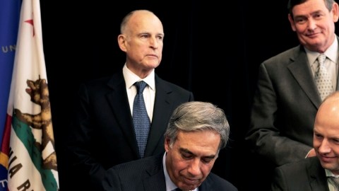San Jose State University President Mohammad Qayoumi, left, signs an agreement to partner with online education startup Udacity to develop a pilot program offering online college classes as Udacity CEO and Co-Founder, Sebastian Thru watches during a news conference on Tuesday, Jan. 15, 2013, in San Jose, Calif. California Gov. Jerry Brown, rear left, California State University Chancellor Timothy White, rear right, watch. Gary Reyes/ Staff) (AP Photo/San Jose Mercury News, Gary Reyes)  MAGS OUT; NO SALES