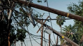 FILE - This Dec. 2, 2011 file photo shows crews from Southern California Edison power company working to clean up and restore power on Live Oak Avenue, in Temple City, Calif. A report by the California Public Utilities Commission faulted Southern California Edison for its response during the 2011 windstorm that left some 440,000 customers in the dark. (AP Photo/Bret Hartman, File)