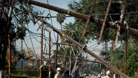 FILE - This Dec. 2, 2011 file photo shows crews from Southern California Edison power company working to clean up and restore power on Live Oak Avenue, in Temple City, Calif. A report by the California Public Utilities Commission faulted Southern California Edison for its response during the 2011 windstorm that left some 440,000 customers in the dark. (AP Photo/Bret Hartman, File)