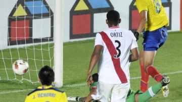José Cevallos (der.) se anticipa a la reacción del portero de Perú  para anotar el segundo gol de Ecuador ayer San Juan, Argentina.