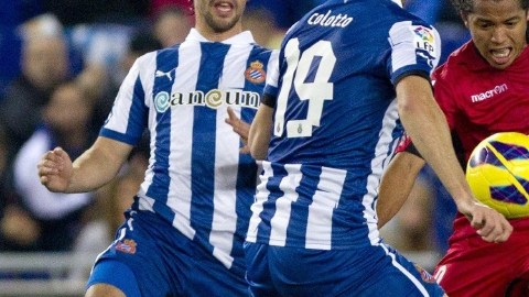 El defensa  del Espanyol Juan Forlin (izq.) y su compañero,  Diego Colotto, disputan un balón con el  Giovani Dos Santos.