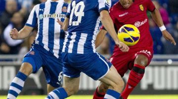 El defensa  del Espanyol Juan Forlin (izq.) y su compañero,  Diego Colotto, disputan un balón con el  Giovani Dos Santos.