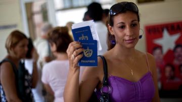 Una mujer muestra su pasaporte y el de su hijo al salir de la oficina de inmigración en La Habana.