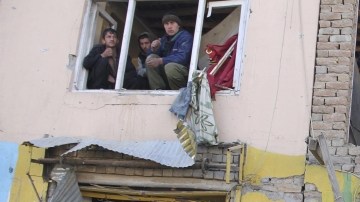 Varias personas inspeccionan un edificio en el lugar donde se ha producido un atentado en Kabul, en Afganistán.