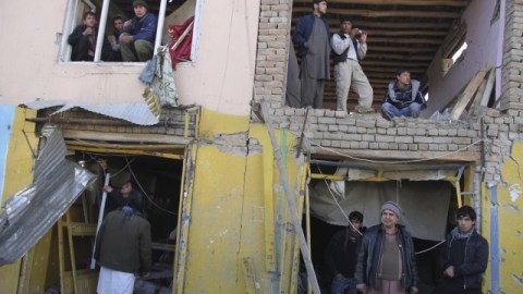 Varias personas inspeccionan un edificio en el lugar donde se ha producido un atentado en Kabul, en Afganistán.