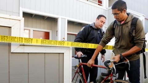 Aaron Illathu, estudiante de UC  Davis, retira su bicicleta del edificio donde hubo una explosión el pasado 17 de enero con la ayuda del agente  Mikkio McCulloch .