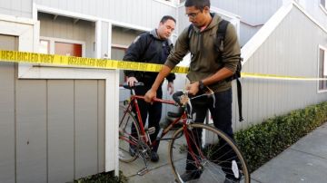 Aaron Illathu, estudiante de UC  Davis, retira su bicicleta del edificio donde hubo una explosión el pasado 17 de enero con la ayuda del agente  Mikkio McCulloch .
