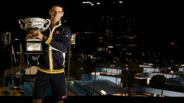 El serbio Novak Djokovic sonríe mientras  posa con su trofeo.