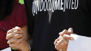 Activistas a favor de la reforma migratoria unían las manos ayer en un acto frente a la Torre de la Libertad  en Miami, Florida
