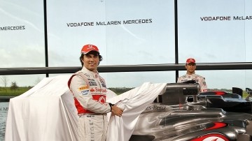 Sergio Pérez (izq.) y Jenson Button, de McLaren, posan tras retirar la lona que cubría el MP4-28.