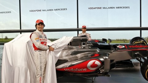 Sergio Pérez (izq.) y Jenson Button, de McLaren, posan tras retirar la lona que cubría el MP4-28.