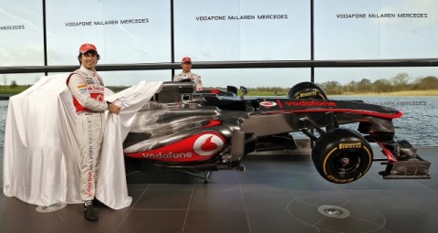 Sergio Pérez (izq.) y Jenson Button, de McLaren, posan tras retirar la lona que cubría el MP4-28.