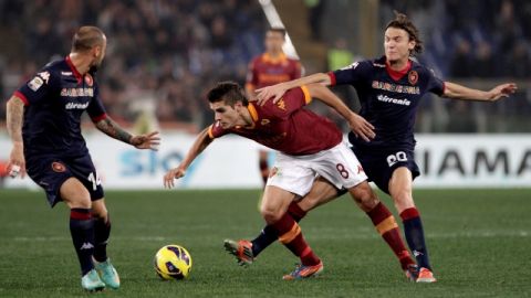 Albin Ekdal (der.), de Cagliari, carga sobre  Erik Lamela (8) de Roma y Francesco Pisano mira expectante. Fue 4-2 en el Estadio Olímpico.