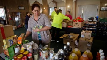 Delia Gudiel preparando bolsas de plástico con comida para darle a la comunidad el sábado por la mañana.