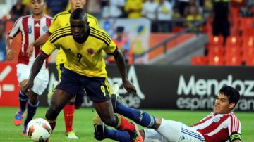 El colombiano John Córdoba (izq.) supera la marca del paraguayo Gustavo Gómez para anotar en el partido que se enfrentaron las dos selecciones en la fase de grupos hoy entre estas dos naciones se decide el título del Sudamericano.
