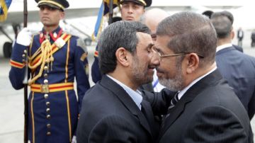 El lider iraní, Mahmud Ahmadineyad (i), y  su homólogo egipcio, Mohamed Mursi, se saludan en  El Cairo,  Egipto.