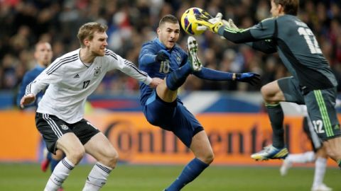 El alemán Per Mertesacker (izq.) y su portero  Rene Adler defienden su meta ante el acoso del delantero francés   Karim Benzema.