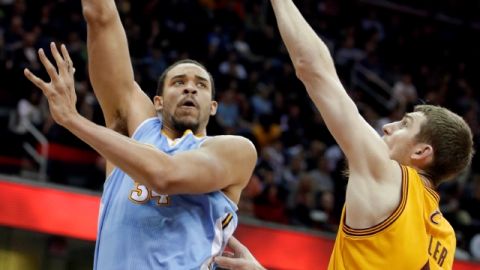 JaVale McGee (izq.), de Nuggets, tira al aro sobre  Tyler Zeller.