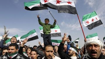 Sirios en Jordania ondean banderas   y corean consignas contra Al Asad, en protesta ante embajada de su país, en  Jordania.