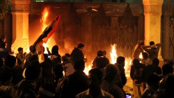 Varias personas prenden fuego a las puertas del palacio presidencial de Itihadiya, en El Cairo, Egipto,  durante una manifestación.