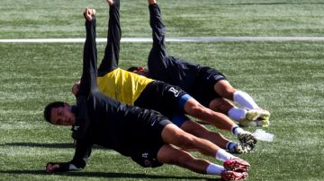 Bien coordinados, los jugadores de Xolos de Tijuana realizan ejercicios de calentamiento.