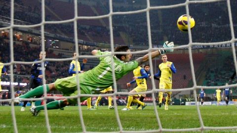 Christian Puggioni, portero de Chievo Verona, va en busca de la pelota pero no puede bloquear el remate a gol de Diego Milito.