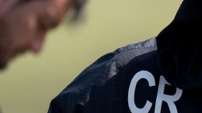 Augusto revisa un par de  tenis en una práctica.