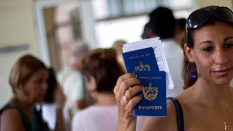 Una mujer muestra su pasaporte cubano que le permite viajar al exterior gracias a la nueva ley migratoria de ese país. A pesar de las especulaciones, no hubo peticiones multitudinarias para salir.