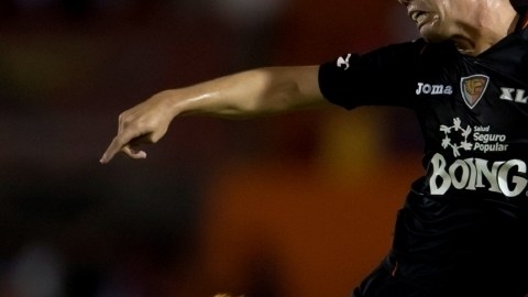 George Corral, de Jaguares, intenta rematar mientras lo observa Fidel Martínez, de Xolos, ayer, en la cancha del  Víctor Manuel Reyna.