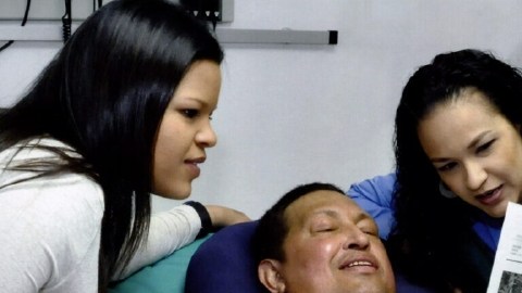 El presidente de Venezuela, Hugo Chávez, junto a sus hijas Rosa Virginia (der.) y María Gabriela (izq.) leyendo el diario oficialista 'Gramna', en La Habana, Cuba.