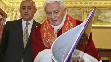 El papa Benedicto XVI muestra un libro al presidente de Guatemala, Otto Pérez Molina, ayer.