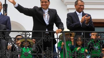 El presidente ecuatoriano, Rafael Correa (izq.), quien fue reelegido el domingo y el vicepresidente electo, Jorge Glass (der.), celebran su triunfo desde el balcón del palacio.