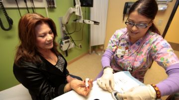 La asistente médica Beatriz Rodríguez le mide el nivel de azúcar a María Barrera en la clínica AltaMed de El Monte, el 'hogar médico' de esta paciente gracias al programa Healthy Way LA.