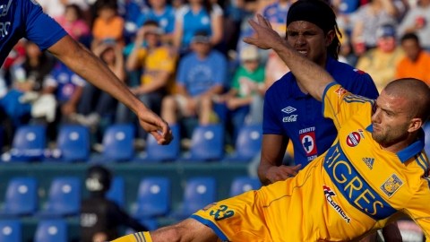 El argentino   Emanuel Villa (al frente) de Tigres, forcejea por el  control del esférico con  Gerardo Flores de  Cruz Azul.