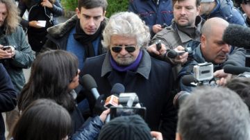 El líder del Movimiento 5 Estrellas, Beppe Grillo (cen.), responde preguntas  a la prensa a su llegada a un colegio electoral en la ciudad de Génova (Italia), ayer.