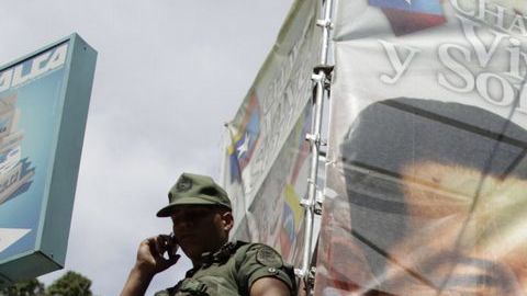 "Chavez vive y sonríe" dice el cartel de la foto. Y Maduro afirma que la recuperación del mandatario "es distinta".