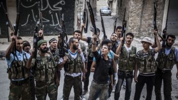 Miembros del Ejército rebelde muestran sus armas y gritan consignas contra el Gobierno  del presidente sirio, Bachar al Asad.