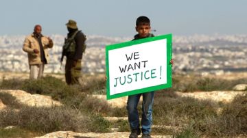 Un soldado israelí rompe una pequeña protesta de palestinos por tierras confiscadas para colonización judia de Sosia, en  la Franja de Gaza.