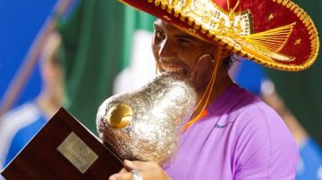 Con sombrero de charro, el español Rafael Nadal besa el trofeo que lo acredita como campeón del Abierto Mexicano.