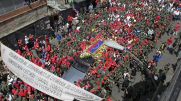 El féretro del difunto presidente de Venezuela, Hugo Chávez, es acompañado por cientos de seguidores ayer,  en Caracas.