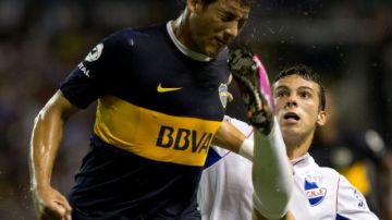 Gonzalo Bueno (der.), del Nacional, le muestra los tachones a Claudio Pérez, del Boca, en acción del juego de ayer en La Bombonera.