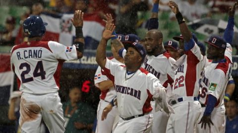 Robinson Canó, de República Dominicana, es felicitado tras  anotar en la primera entrada del juego de ayer.