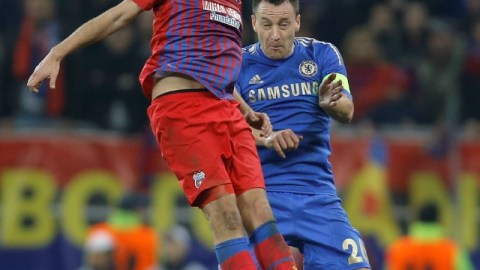 John Terry, del Chelsea, salta atrás del jugador del Steaua de Bucarest, Raul Rusescu, en el juego de ayer celebrado en el National Arena.