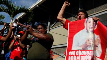 Venezolanos llamados "chavistas" mantienen el ánimo mientras este viernes esperan en fila para poder ofrecer sus respetos al cuerpo del presidente Hugó Chávez.