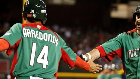 Adrián González (der.) felicita a Eduardo Arredondo, quien anota una carrera en la primera entrada del juego de ayer en el Chase Field.