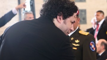 El maestro Gustavo Dudamel toca el hombro de   Elena Frías, madre del presidente venezolano Hugo Chávez, mientras su otro hijo Argenis mira al director de orquesta en la ceremonia del funeral.