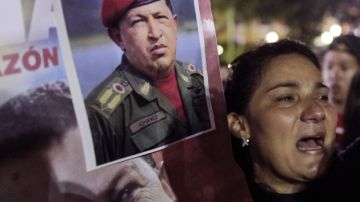 Una seguidora del presidente Hugo Chávez llora mientras muestra un afiche con su retrato en la Plaza Bolívar de Caracas.
