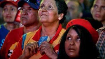 Simpatizantes de Maduro observan, mediante la televisión, la juramentación del funcionario como "presidente encargado" de Venezuela.