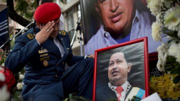 Un hombre saluda un sitio dedicado a Hugo Chávez en las afueras de la Embajada de Venezuela en Buenos Aires.