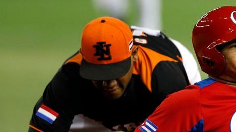El cubano Frederich Cepeda se va de "out" tras la intervención del primera base holandés Curt Smith. Holanda derrotó hoy a Cuba 7-6.